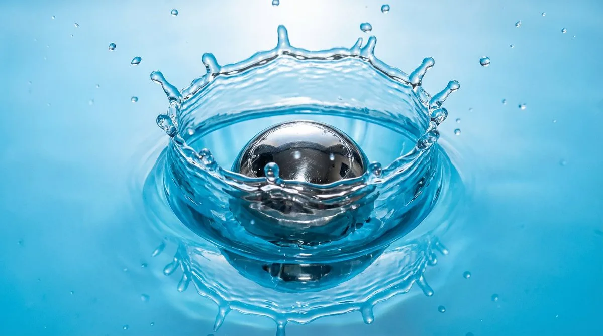 Metal ball dropping into water slow-motion splash (Premium)